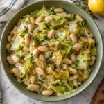 Overhead view of cabbage and white beans in a square composition around a sage-green bowl.