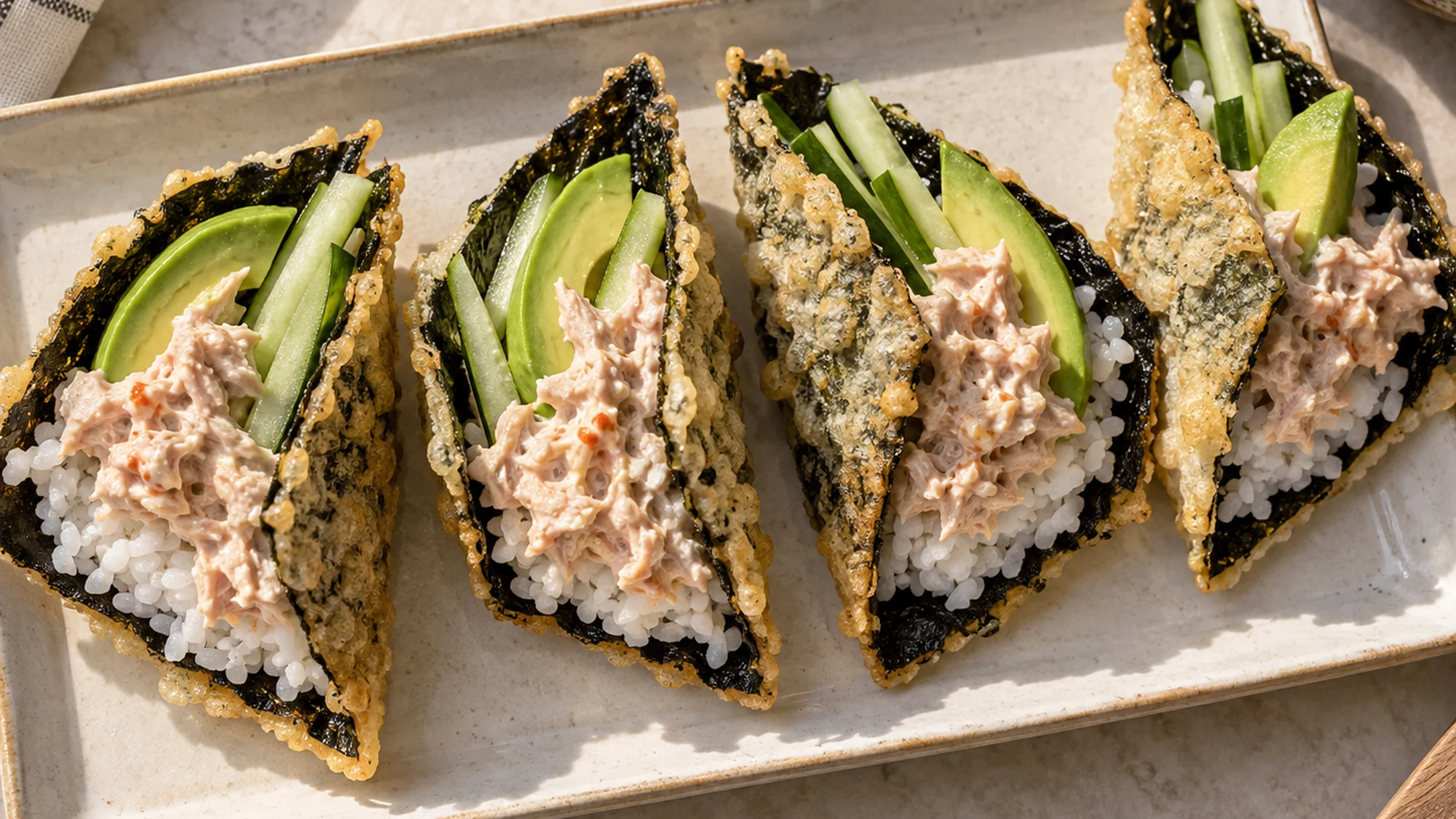 Four spicy tuna nori tacos arranged on a platter.