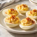 Square close view of classic deviled egg halves with creamy filling