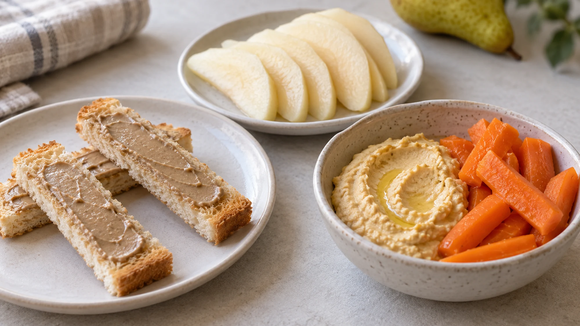 Toast fingers with a thin spread, soft pear slices and hummus with cooked carrots