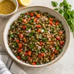 Square view of lentil salad with red pepper, onion and parsley.