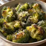 Square image of Parmesan roasted frozen broccoli with golden edges and lemon.