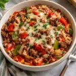 Square view of stuffed pepper casserole with beef, white rice, diced peppers, tomato sauce and melted mozzarella.