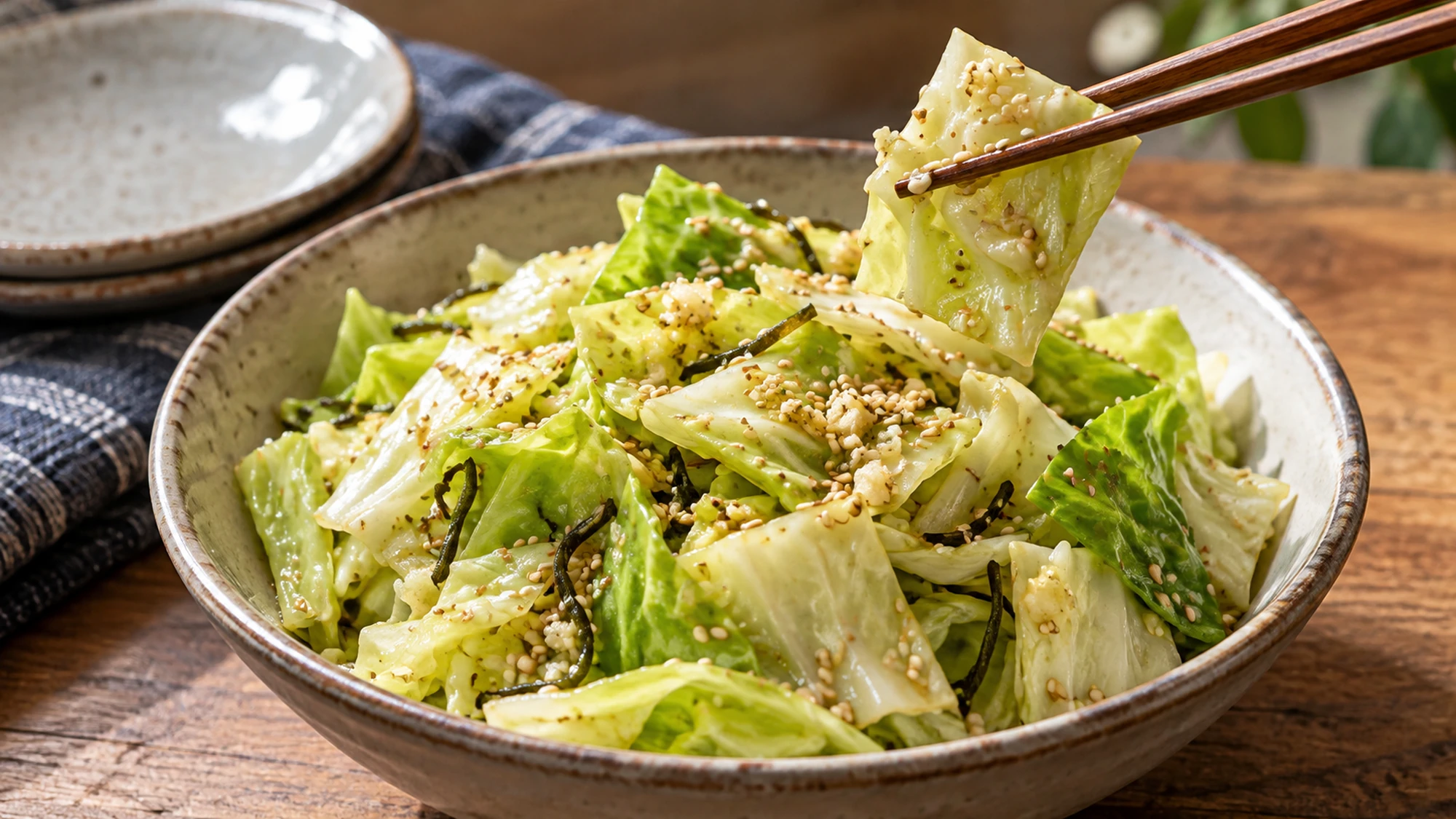 Close view of crisp cabbage squares coated evenly in savory sesame oil with toasted sesame.